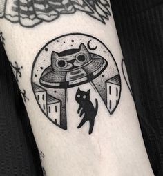 a black and white photo of a cat with an alien ship on it's arm