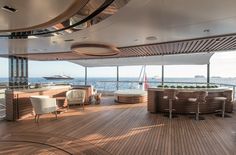 the inside of a boat with chairs, tables and hot tubs on it's deck