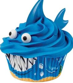 a cupcake with blue frosting decorated like a shark's mouth and teeth