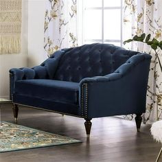 a blue couch sitting on top of a hard wood floor next to a white rug