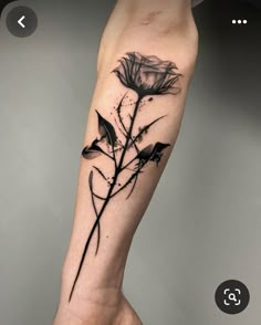 a black and white flower tattoo on the arm