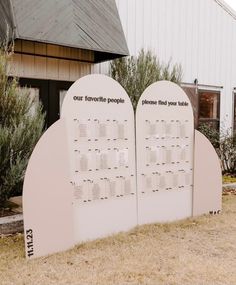 two large white signs sitting next to each other in front of a building