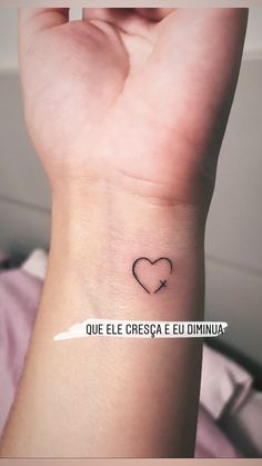 a small heart tattoo on the wrist that reads que el cresca e dimua