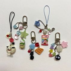 several different key chains with charms attached to them on a white surface in various shapes and sizes