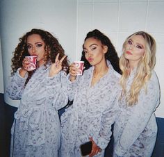 three women in matching robes holding up cups