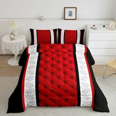 a bed with red and black comforters in a room