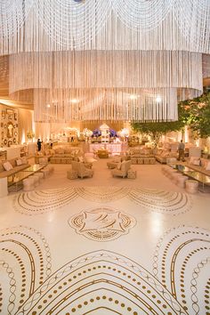 a large room with chandeliers hanging from the ceiling and couches on the floor