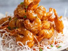 a pile of fried shrimp with parmesan cheese and sauce on a white plate