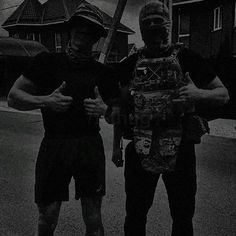 two men standing next to each other on the street with skateboards in their hands