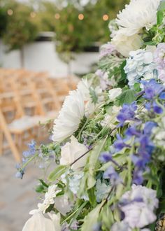 a bunch of flowers that are sitting in front of some chairs