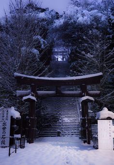 the entrance to atago shrine is covered in snow and has steps leading up to it