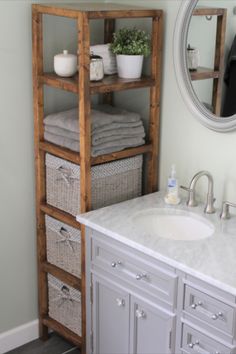 a bathroom with a sink, mirror and shelving unit in the middle of it