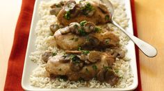 chicken with mushrooms and white rice on a red table cloth next to a spoon in it