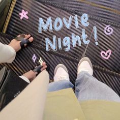 two people sitting on an escalator and writing move night