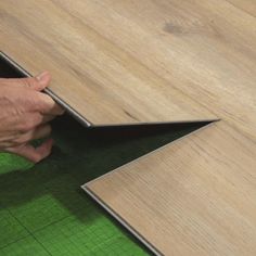 a person is working on wood flooring with the help of a tape measure ruler