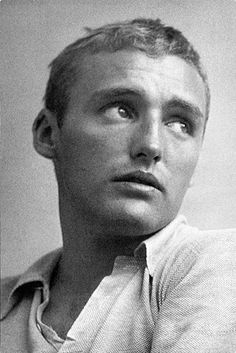 an old black and white photo of a man in a polo shirt looking at the camera