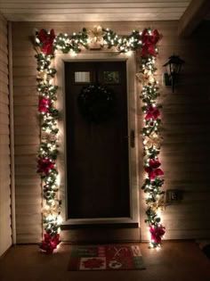 the front door is decorated with christmas lights and poinsettia garlands for holiday decor