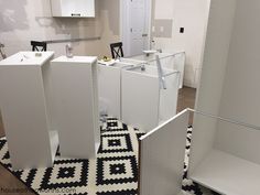 a kitchen with white cabinets and black and white flooring