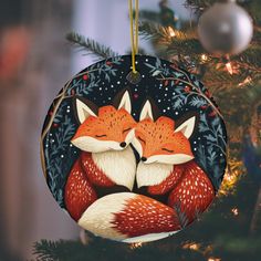 a christmas ornament with two foxes on it