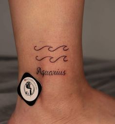 a small tattoo on the ankle that says aquarius