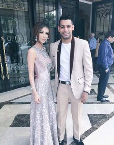 a man and woman standing next to each other in front of a glass door at an event