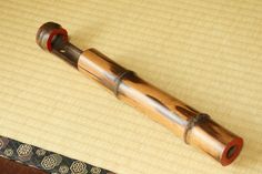 an old wooden pipe laying on top of a table next to a decorative piece of cloth