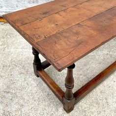 an old wooden table sitting on top of a cement floor