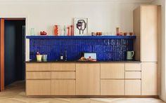 a kitchen with wooden cabinets and blue tile backsplashing on the counter top