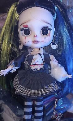 a doll with black and white hair wearing a dress