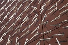 many metal arrows are arranged on a red surface with white lines in the center and one arrow is pointing upward