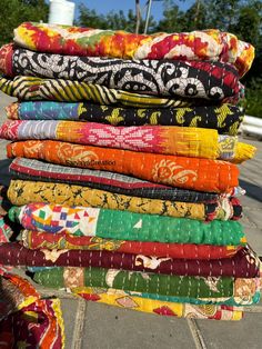 a stack of colorful fabrics sitting on top of each other in front of a building