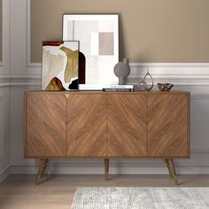 a wooden sideboard with a painting on top of it next to a rug and vase