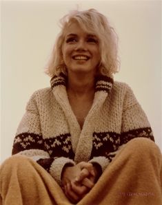 a woman sitting in the sand with her legs crossed