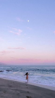 a person walking on the beach at sunset