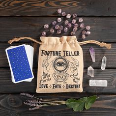 a fortune teller bag next to other items on a wooden table with beads and stones