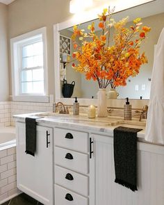 a bathroom with a sink, mirror and flowers in the vase on the counter top