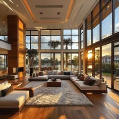 a large living room with lots of windows and couches on top of the wooden floor