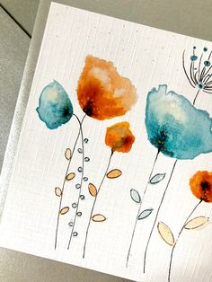 an art work with watercolors on paper, depicting blue and orange flowers in different colors