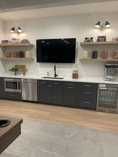 a large flat screen tv mounted to the side of a wall above a kitchen sink