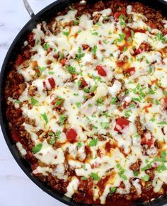 a pizza in a skillet with cheese, meat and vegetables on the top is ready to be eaten