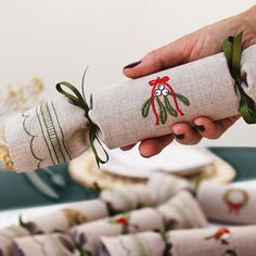 a person holding a rolled up piece of fabric in front of stacks of folded napkins