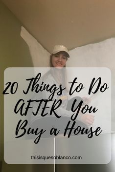 a woman standing in front of a white sign with the words 20 things to do after you buy a house