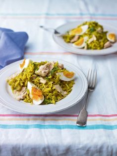 two plates of food on a table with silverware