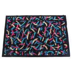 a black rug with multicolored ribbons on the front and back of it's edges