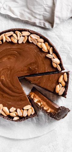 there is a chocolate pie with nuts on the top and one slice missing from it