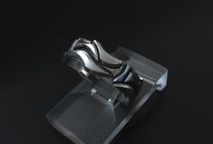 a silver and black object sitting on top of a glass stand in the middle of a dark room