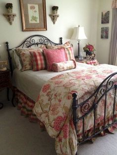 a bed sitting in a bedroom next to a window with curtains on the windowsill