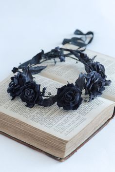 an open book with black roses on it