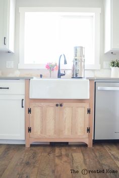 a kitchen with white cabinets and wood flooring is featured in the article diy reclaimed wood sink cabinet