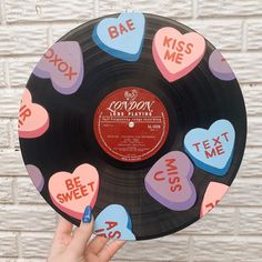 someone is holding up a record with hearts on it and the words kiss me written on it